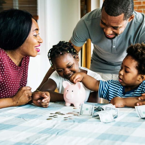 family putting money in piggy bank